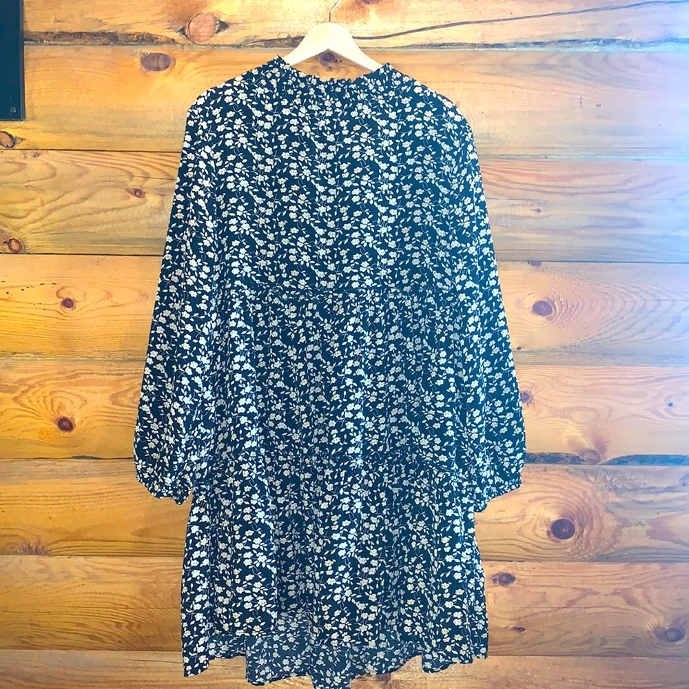 Floral-patterned, black long sleeve mid-length dress.